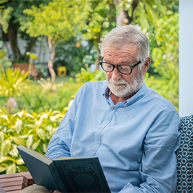 Man reading book in a garden